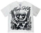 A white short-sleeve graphic t-shirt featuring a black and white illustration of two cherubs with wings, the text 'Maple Hills' in cursive, and 'Spade Eye Studios' at the bottom. A hangtag is visible at the collar.
